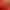Une cocotte rouge avec un couvercle en fonte est posée sur une plaque de cuisson, contenant des aliments en train de cuire